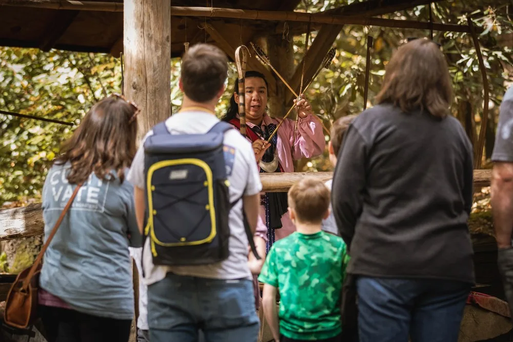 Visitors watching a Cherokee cultural demonstration at Oconaluftee Indian Village